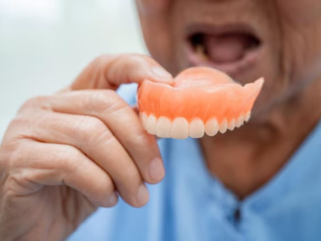 person holding a partial denture to demonstrate removable tooth replacement for missing teeth